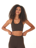 Dark brown women's sports bra featuring a scoop neckline and strappy back design against a neutral background.