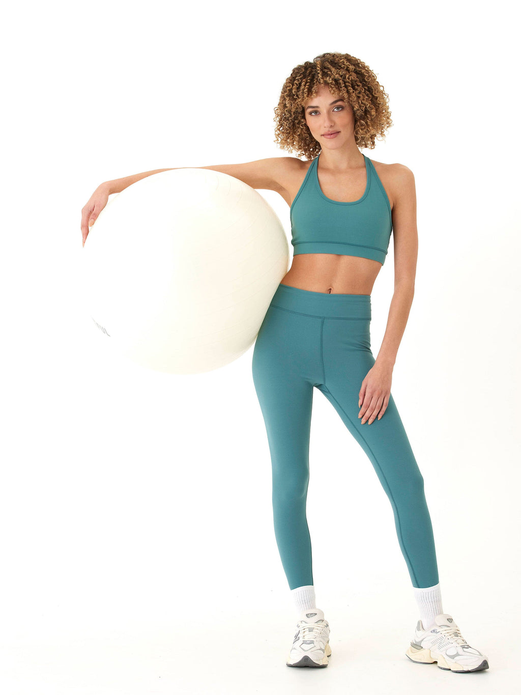 A pair of solid muted teal high rise 7/8 ankle leggings with a tapered, fitted silhouette for athletic use.