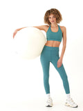A pair of solid muted teal high rise 7/8 ankle leggings with a tapered, fitted silhouette for athletic use.