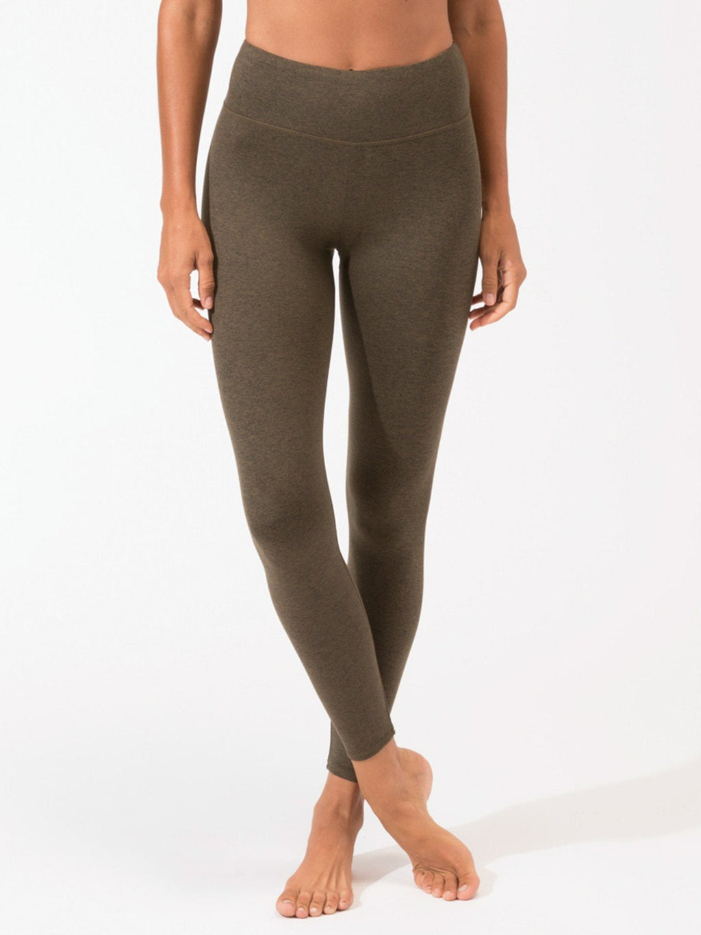 Woman wearing olive green high-rise ankle length leggings in a minimalist sporty style.