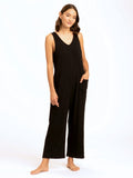 Woman wearing a relaxed-fit, sleeveless black wide-leg jumpsuit with patch pockets
