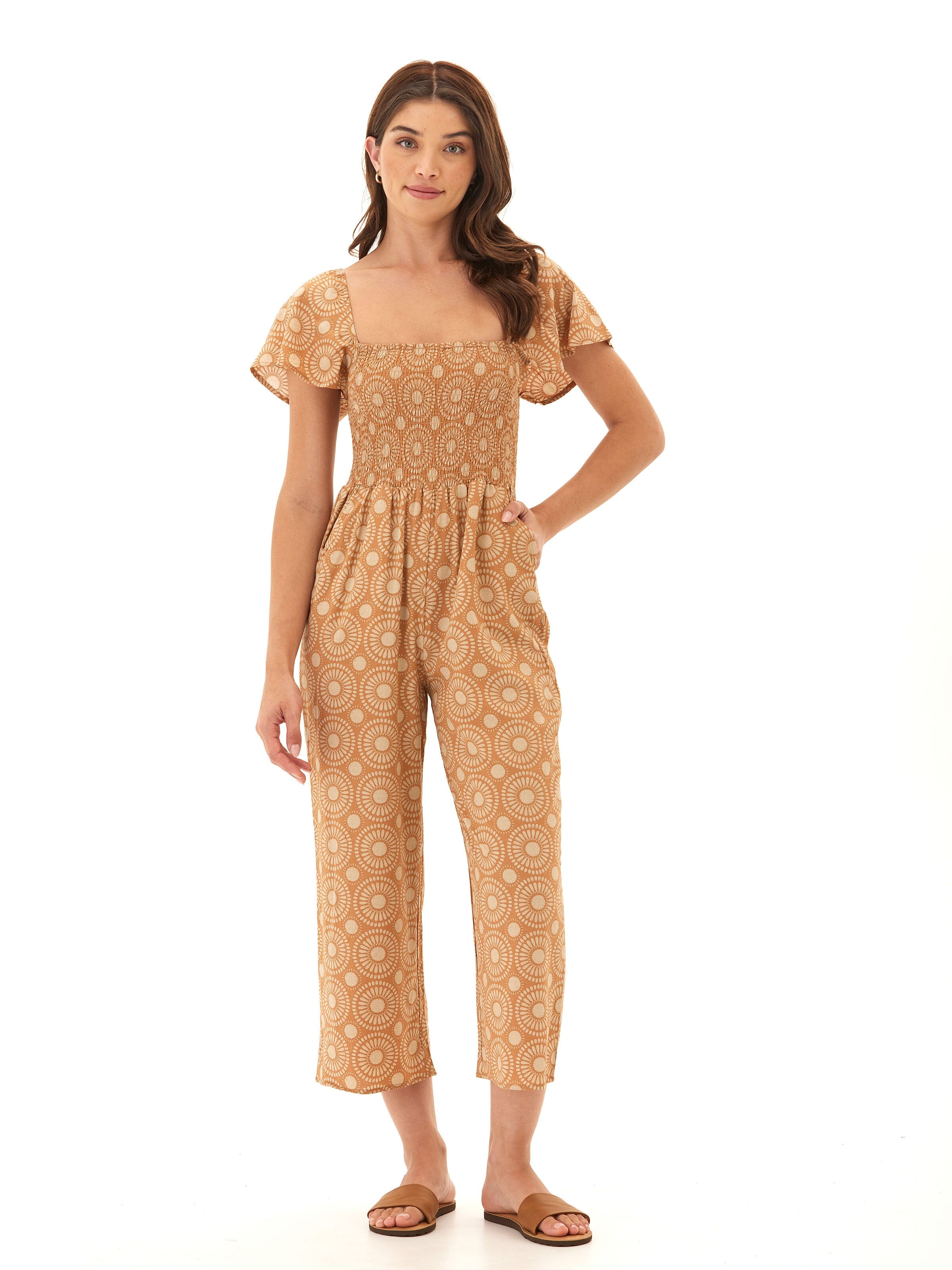 Model wearing a Lucille Medallion print woven jumpsuit with a smocked bodice and flutter sleeves