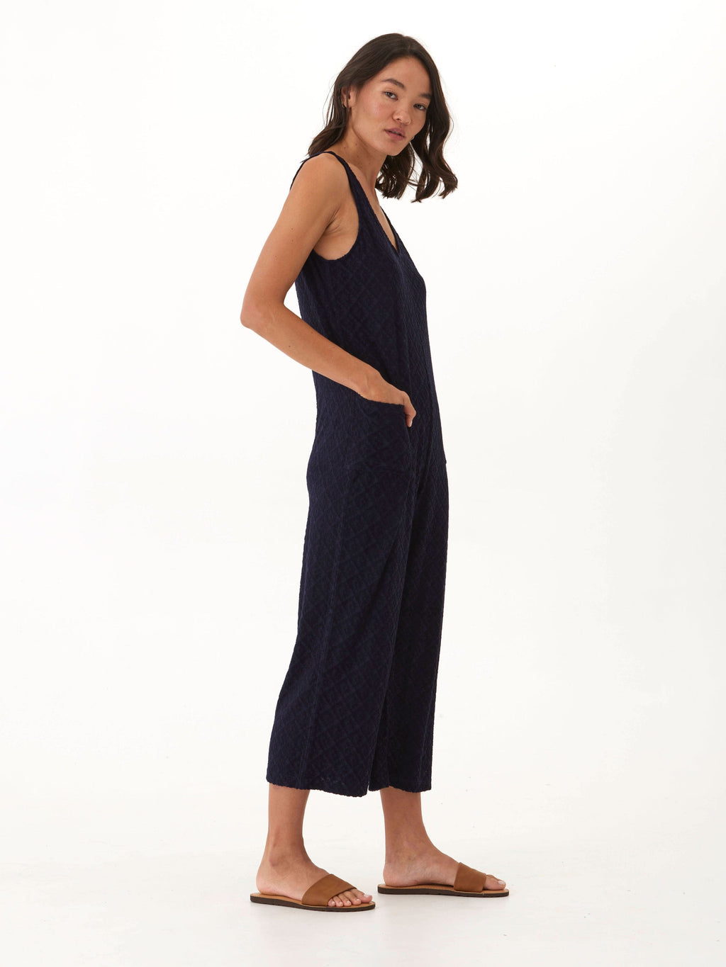 Model wearing a relaxed, cropped wide-leg Jacquard Terry jumpsuit in a textured finish with visible patch pockets.