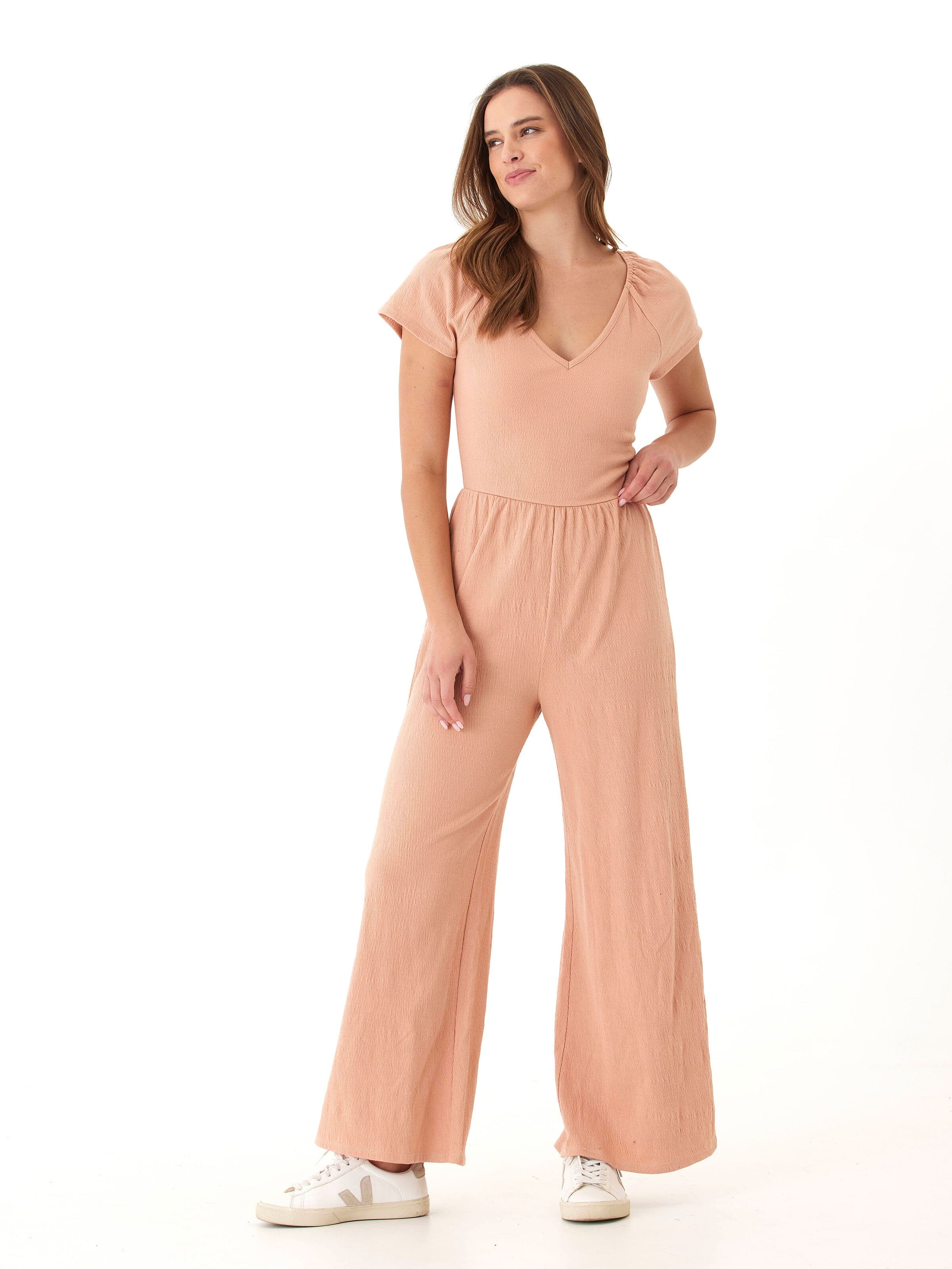 Peach wide-leg flutter sleeve jumpsuit with V-neckline and smocked details