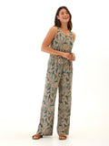 Woman wearing a sleeveless teal and peach floral print wide-leg jumpsuit with scoop neckline and elastic waist.