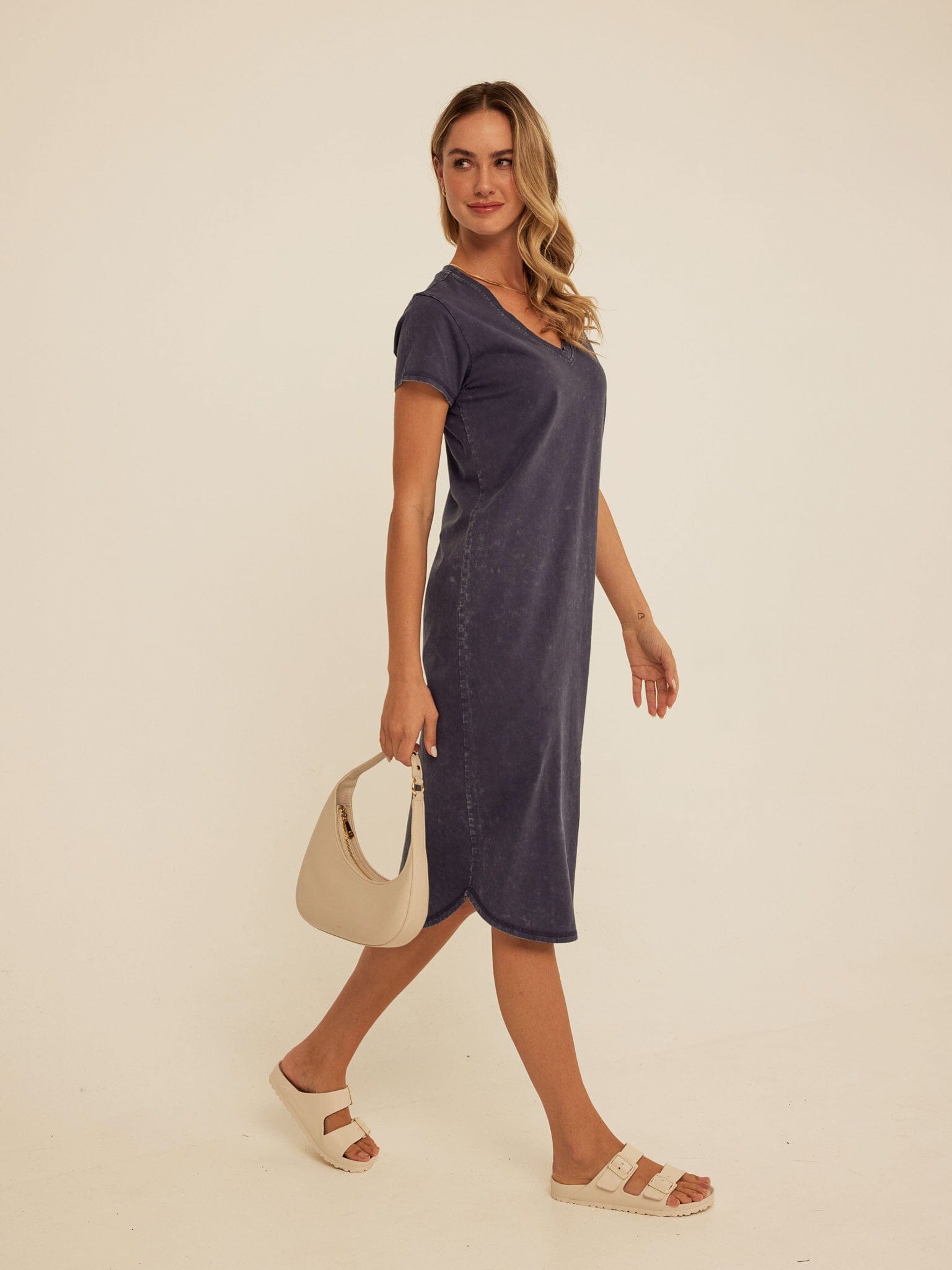 A woman wearing a charcoal mineral wash Eco Jersey midi dress with a V-neck and relaxed fit.