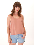 Woman wearing a flowy organic cotton gauze scoop neck tank in Dusty Rose.