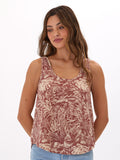 Woman wearing a flowy rust-colored Syrena organic cotton gauze tank with scoop neck design.