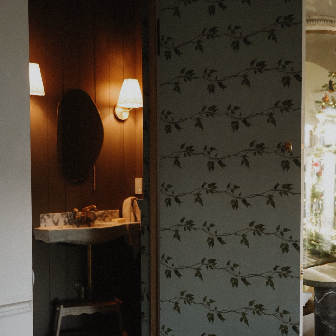 Close up of sage green and dark forest green botanical patterned removable wallpaper