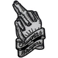 Close up of a black and white iron-on patch featuring an engraved style hand with fingers crossed.