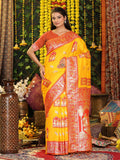 Beautiful yellow silk saree with a contrasting orange blouse piece for festive wear