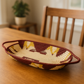 A decorative Royal Harvest Tray in earth tones featuring geometric patterns sitting on a coffee table.
