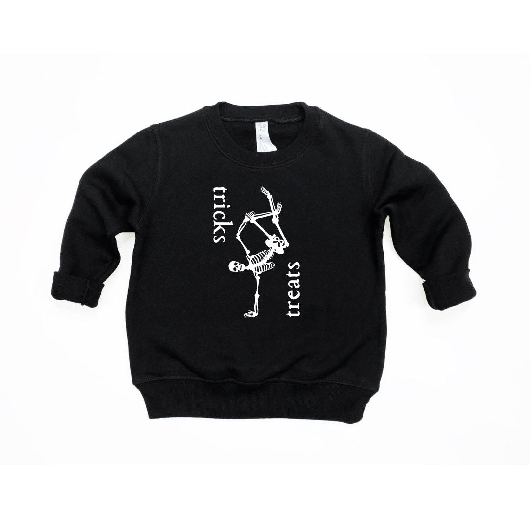 Child wearing a black Tricks & Treats pullover with gothic-style graphic