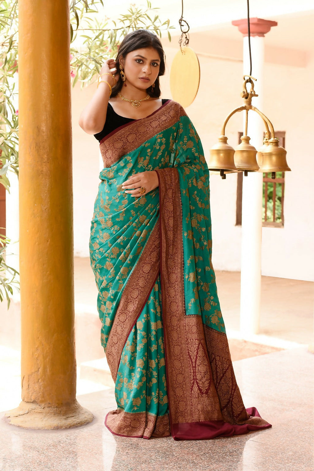 Teal green crepe chiffon handloom Banarasi silk saree with elegant drape.