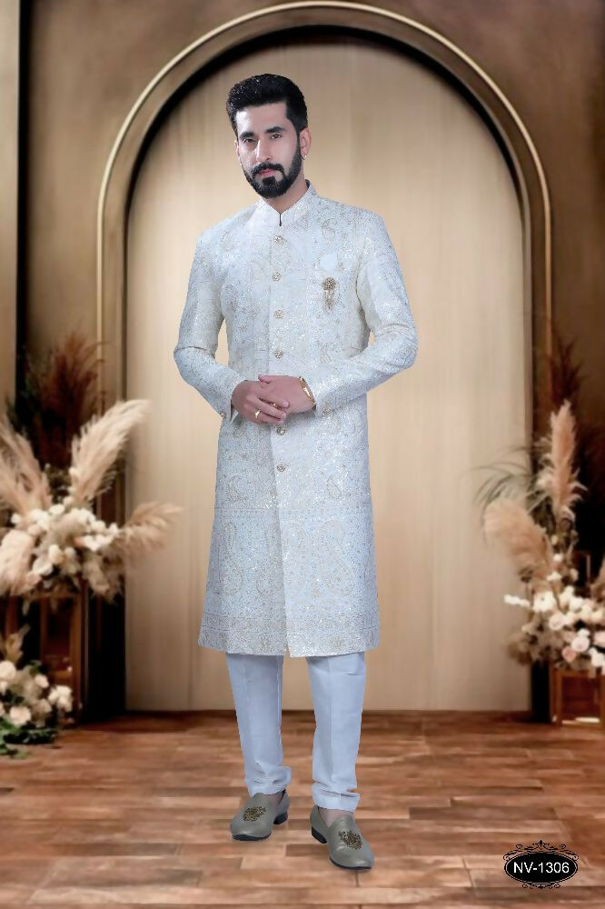 Stunning white silk sherwani for boys with heavy thread and sequence embroidery detail.