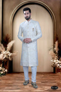 Stunning white silk sherwani for boys with heavy thread and sequence embroidery detail.