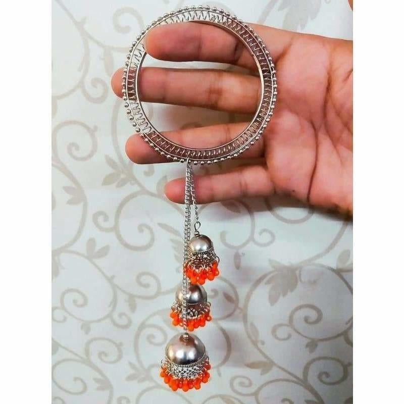 Silver-tone bangle with three hanging jhumka charms and orange pearls