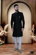 Young boy wearing a black self-design Indo-Western kurta with matching pyjama trousers