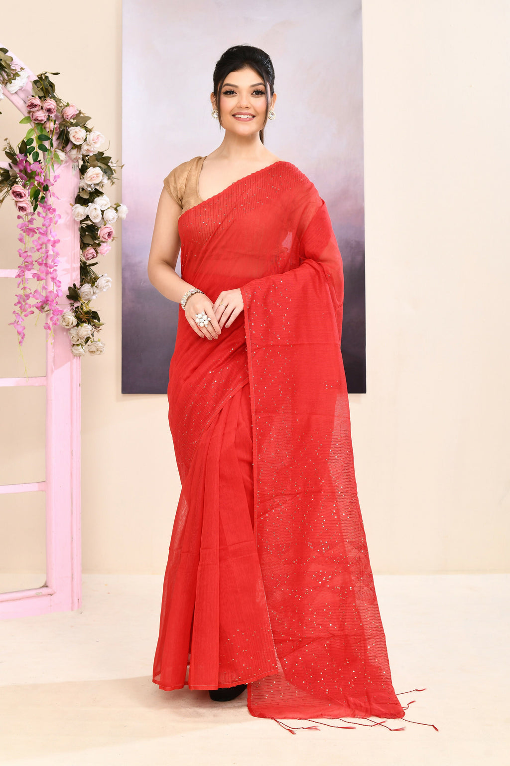 A vibrant red cotton blend Jamdani saree featuring delicate self-sequin embellishments.