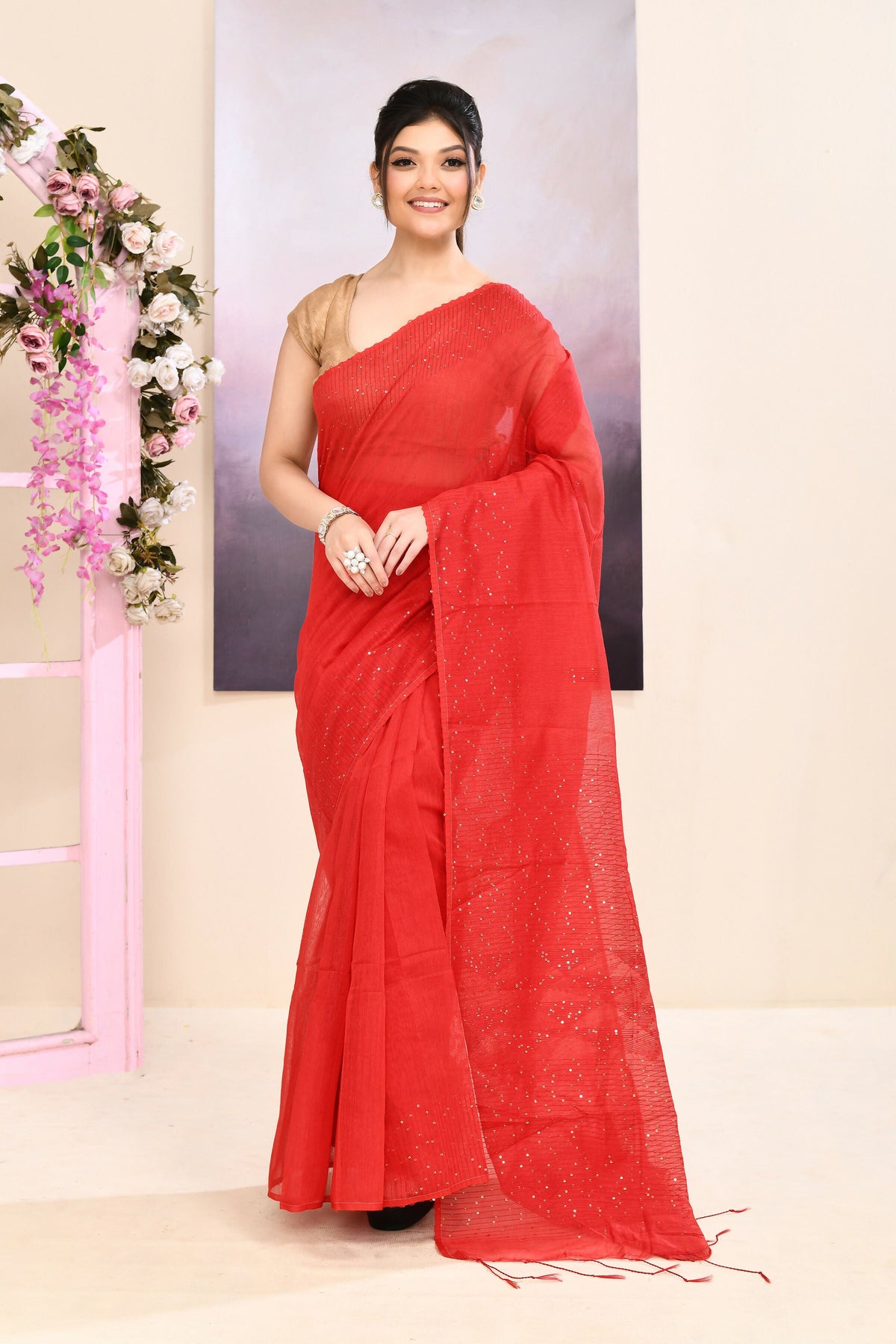 A vibrant red cotton blend Jamdani saree featuring delicate self-sequin embellishments.