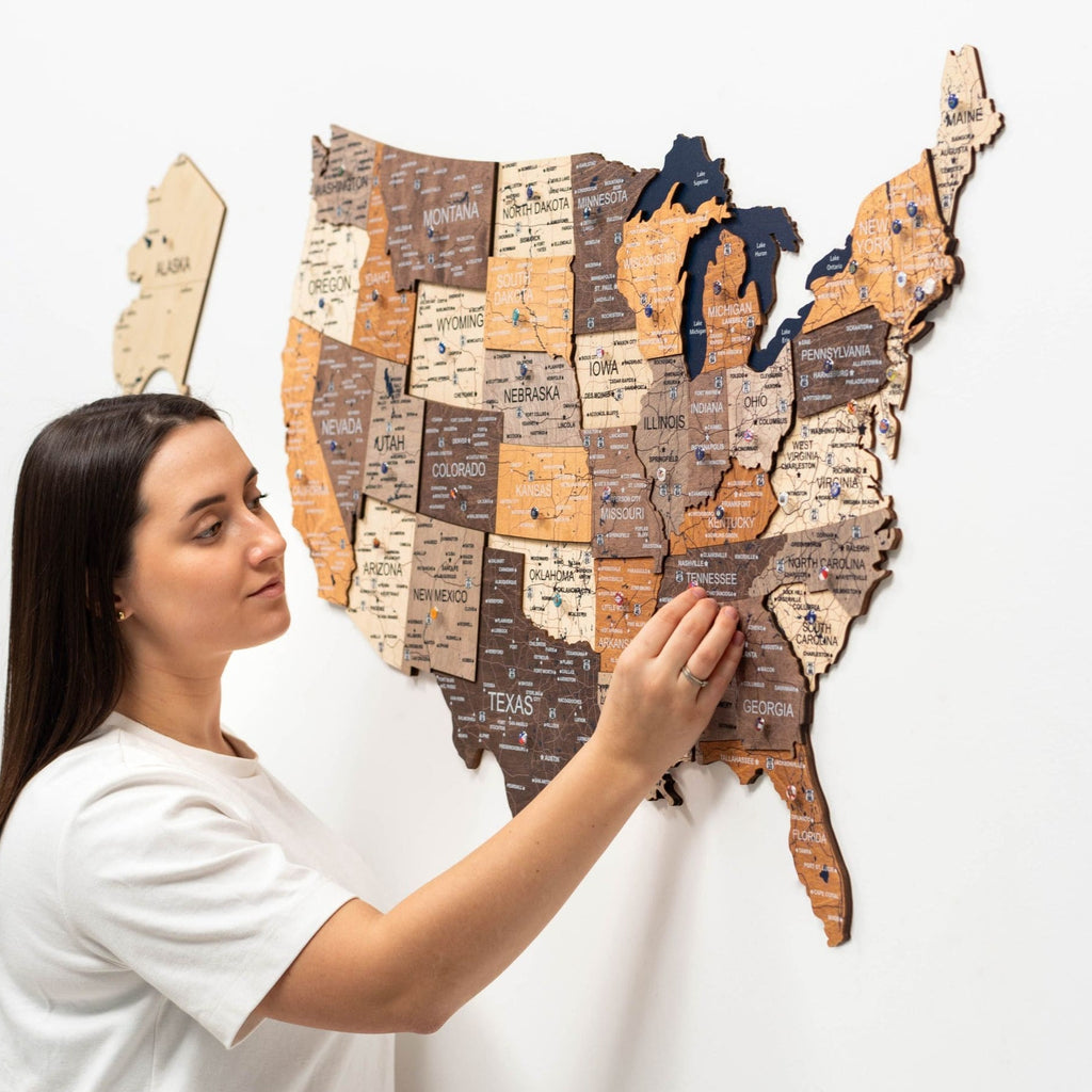 3D wooden map of the USA featuring natural beige wood and navy-blue accents on a clean wall.