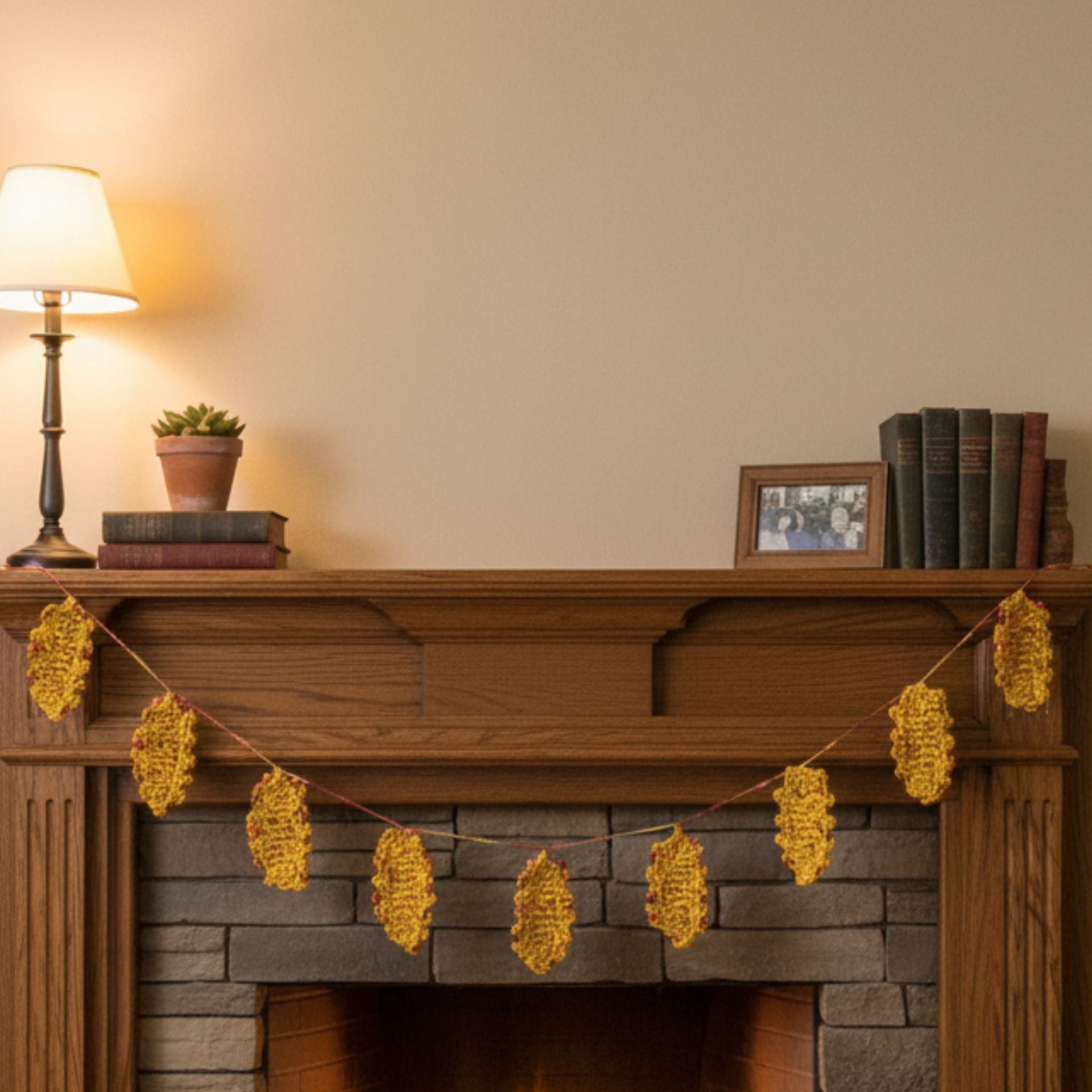 Close up of handmade knit fall leaves in golden yellow and rusted red for seasonal farmhouse home decor.
