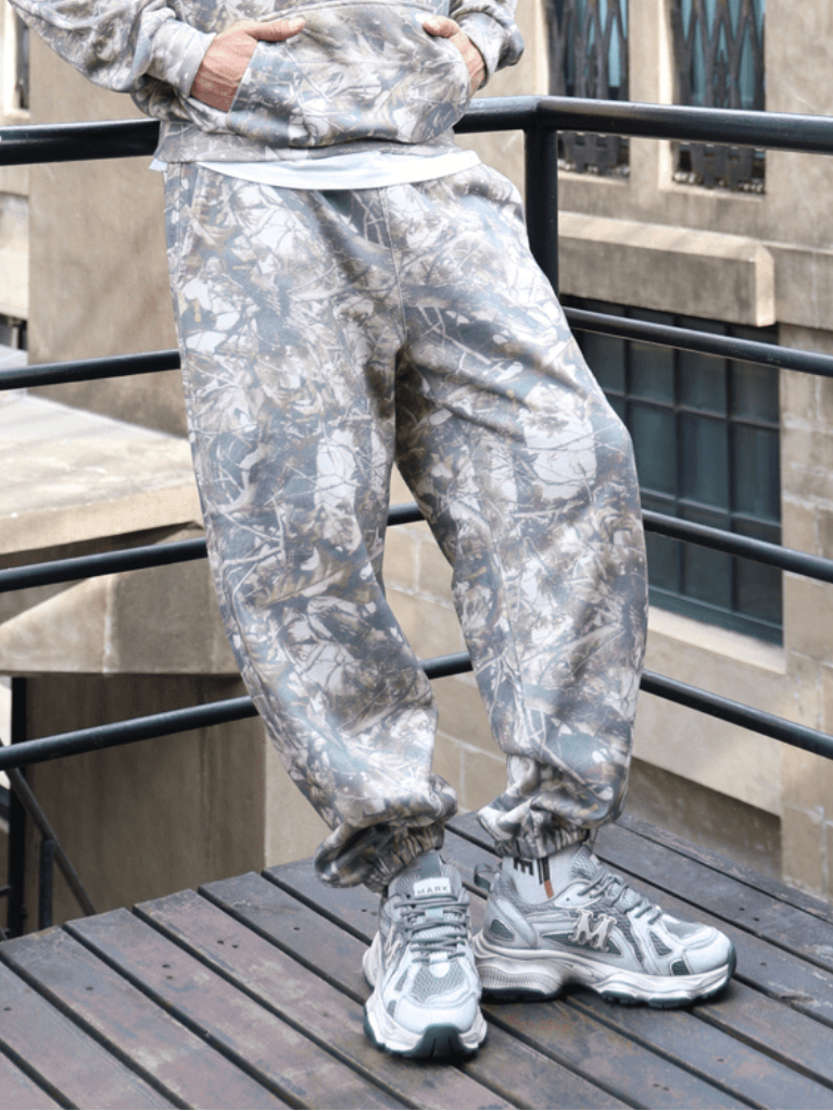 Unisex oversized heavyweight French Terry sweatpants in botanical camo featuring grey, brown, and white tones