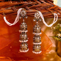 Oversized antique golden multi-layered jhumka earrings with pearl accents and traditional earchains for women