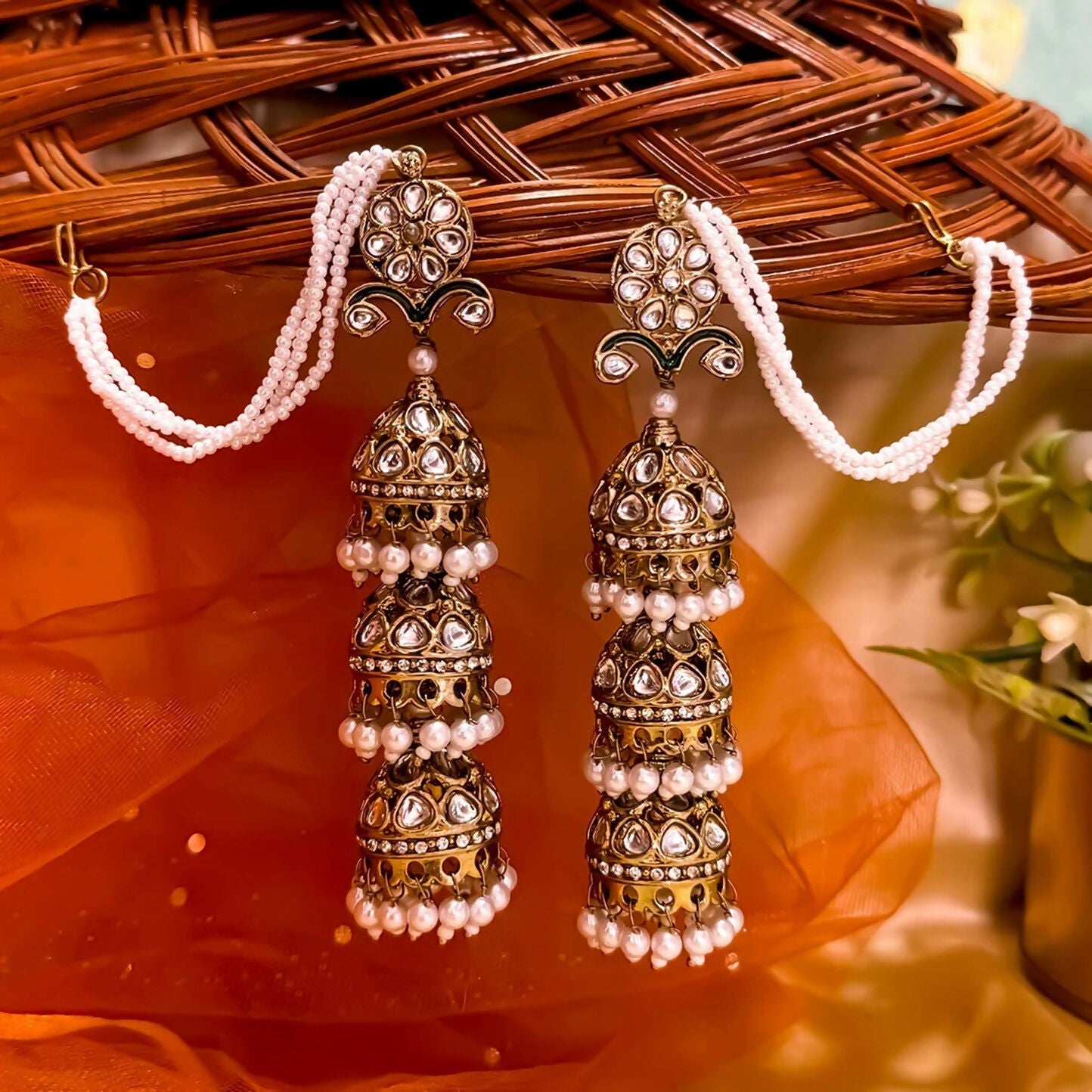 Oversized antique golden multi-layered jhumka earrings with pearl accents and traditional earchains for women