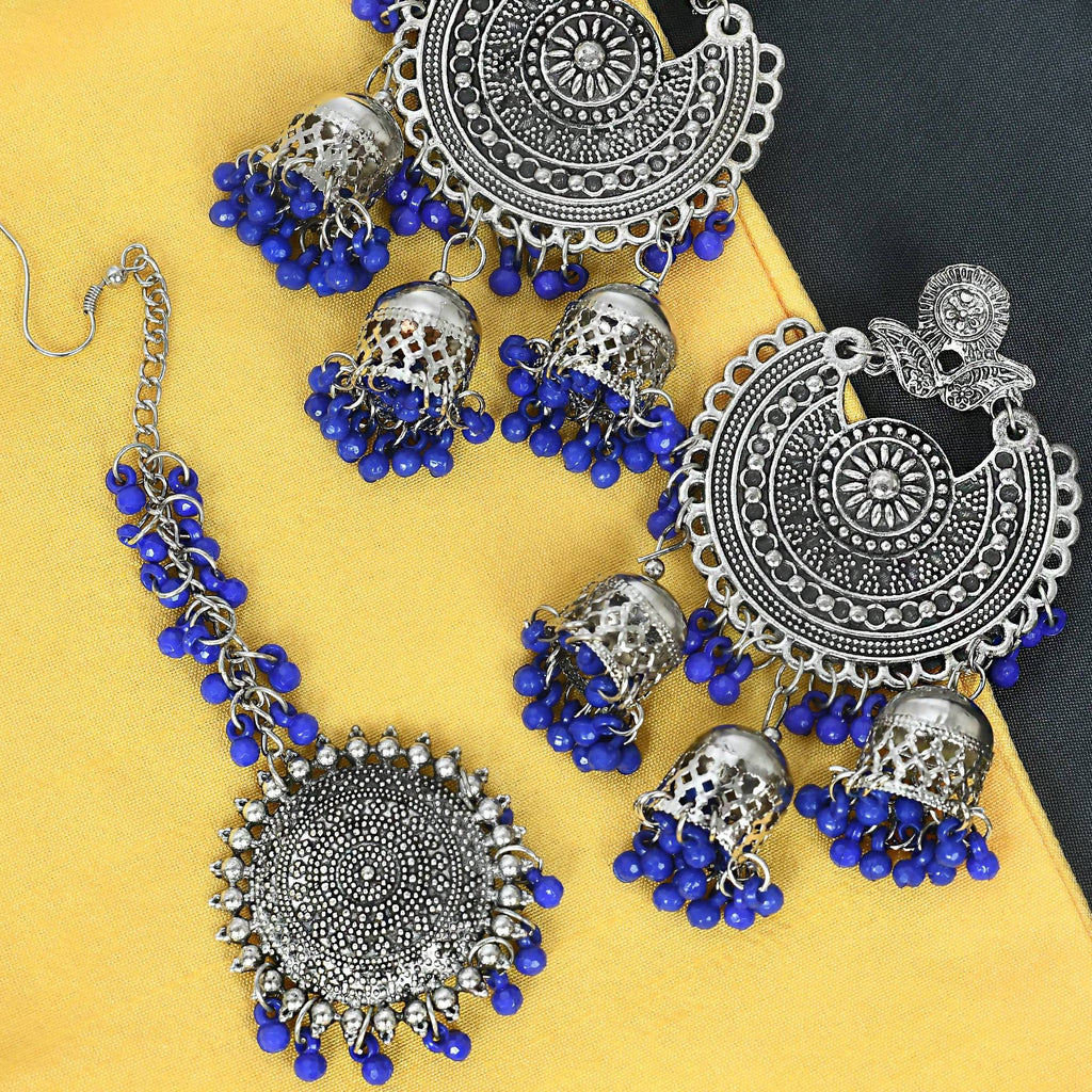 Silver tone Jhumka earrings paired with a matching traditional Maang Tikka