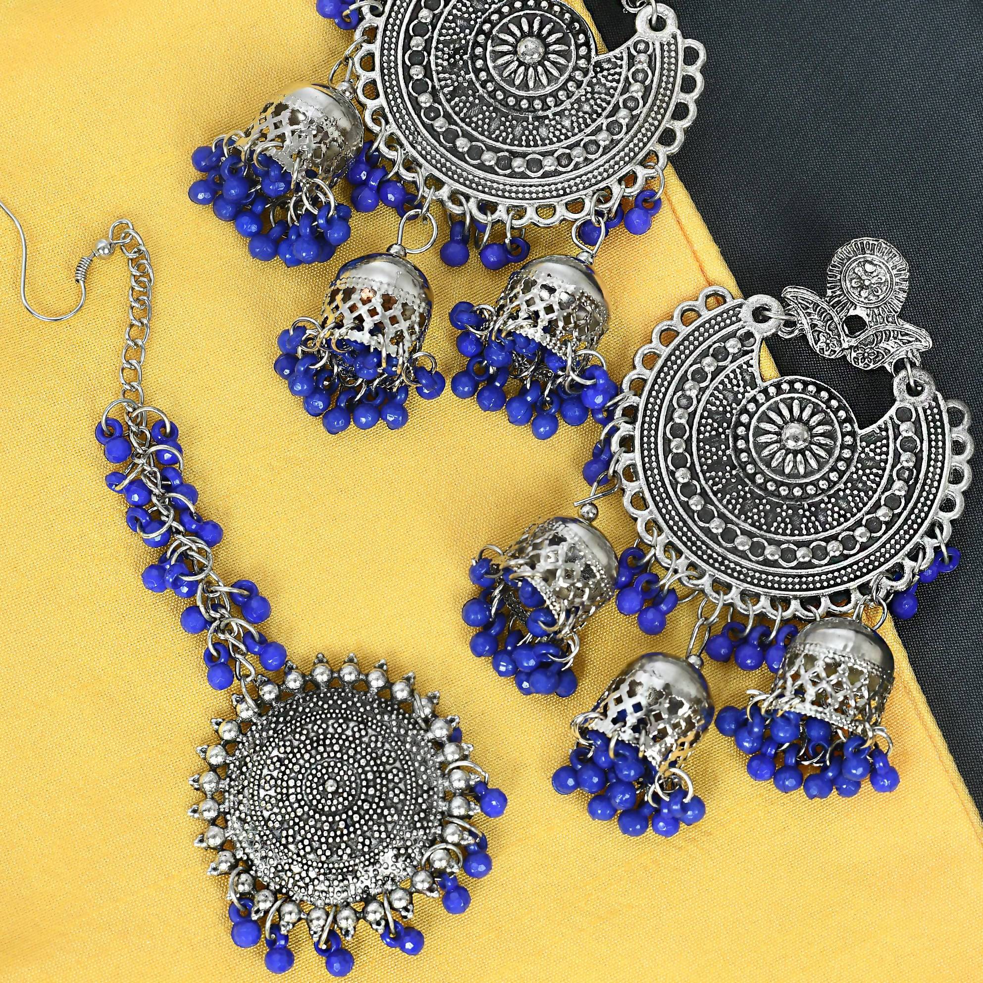 Silver tone Jhumka earrings paired with a matching traditional Maang Tikka