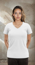 A woman wearing a classic white V-neck t-shirt standing against a neutral background.
