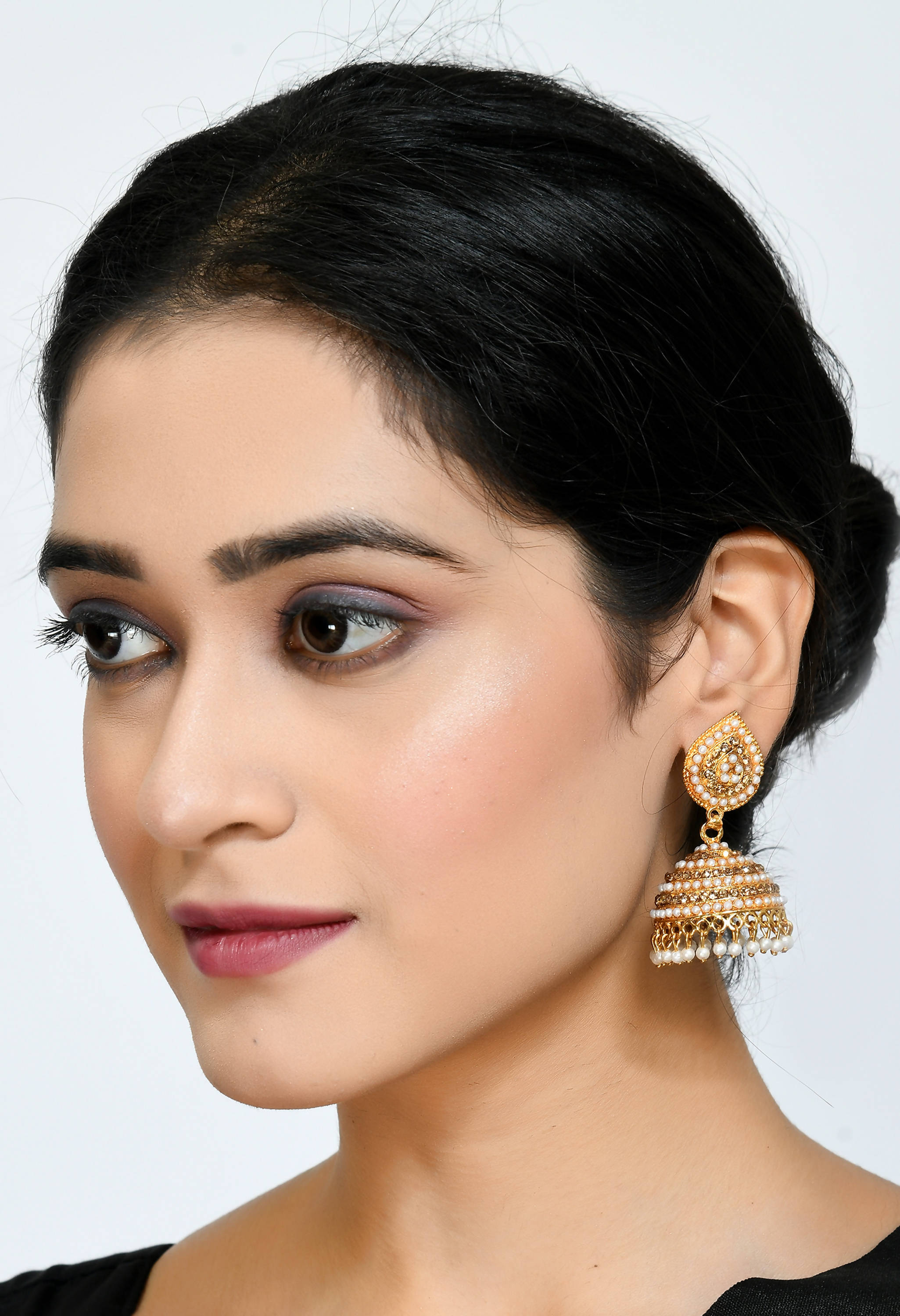 Golden Johar Kamal leaf design jhumka earrings decorated with white pearls and stones for girls.