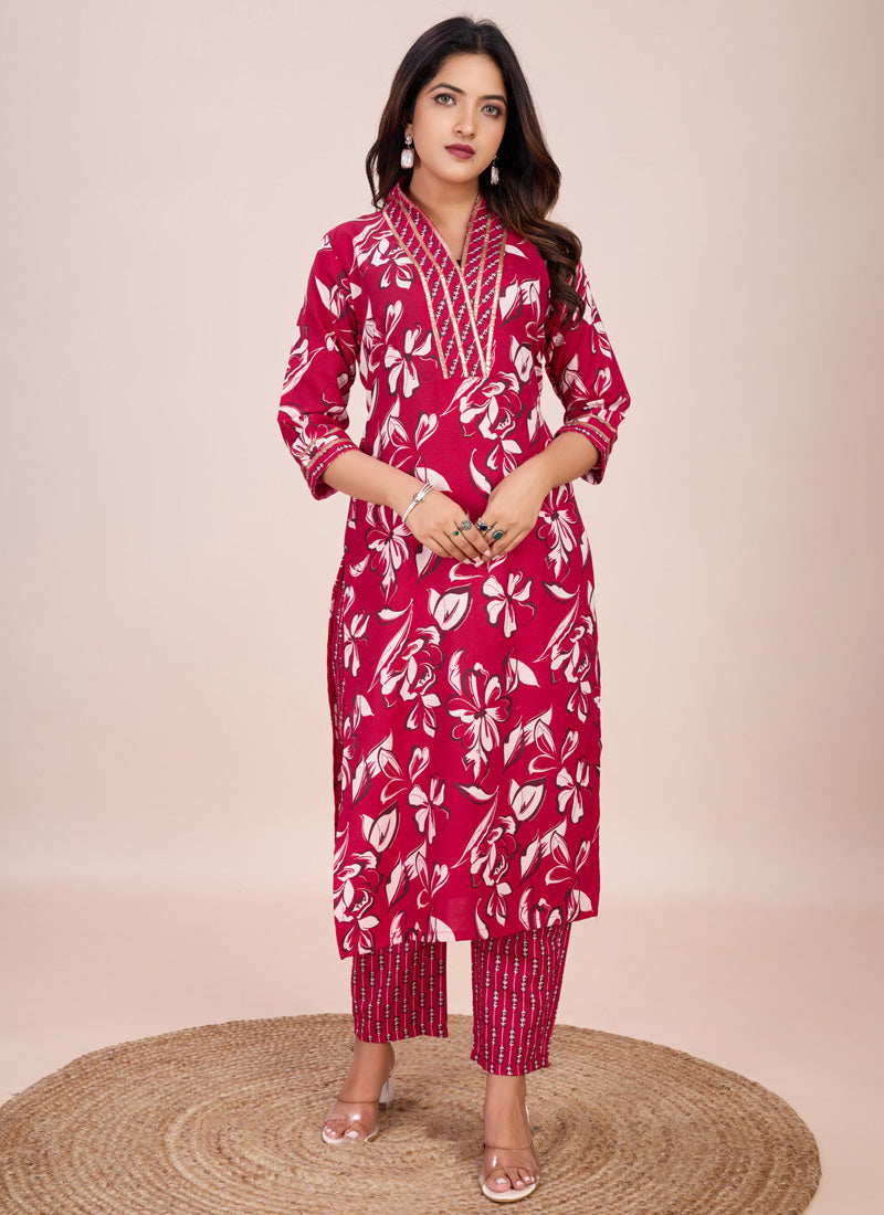 A woman wearing a pink printed cotton blend kurta and matching trousers set.