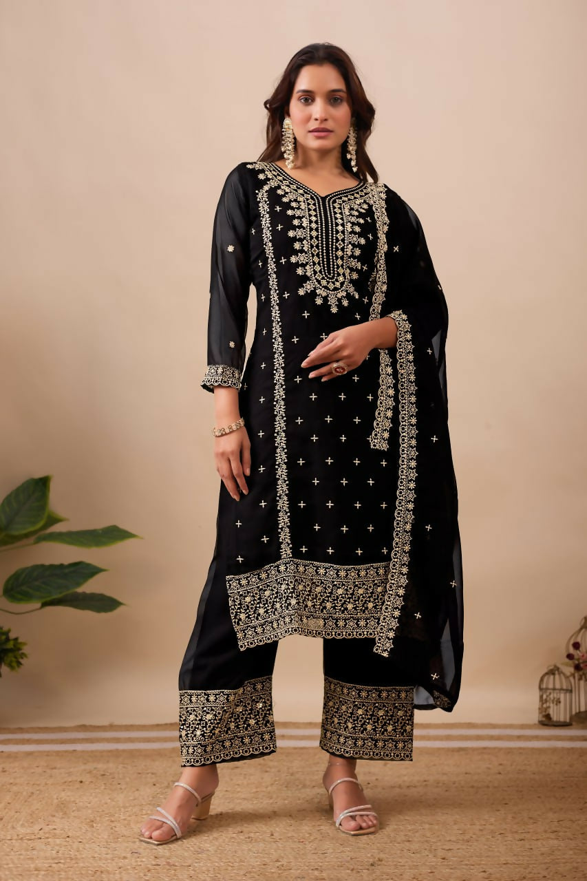 Model wearing a luxury black velvet kurta set with intricate embroidery and sequence detailing