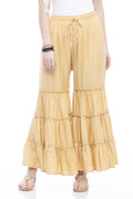 Woman wearing solid golden rayon cotton palazzo pants in a wide-leg silhouette.