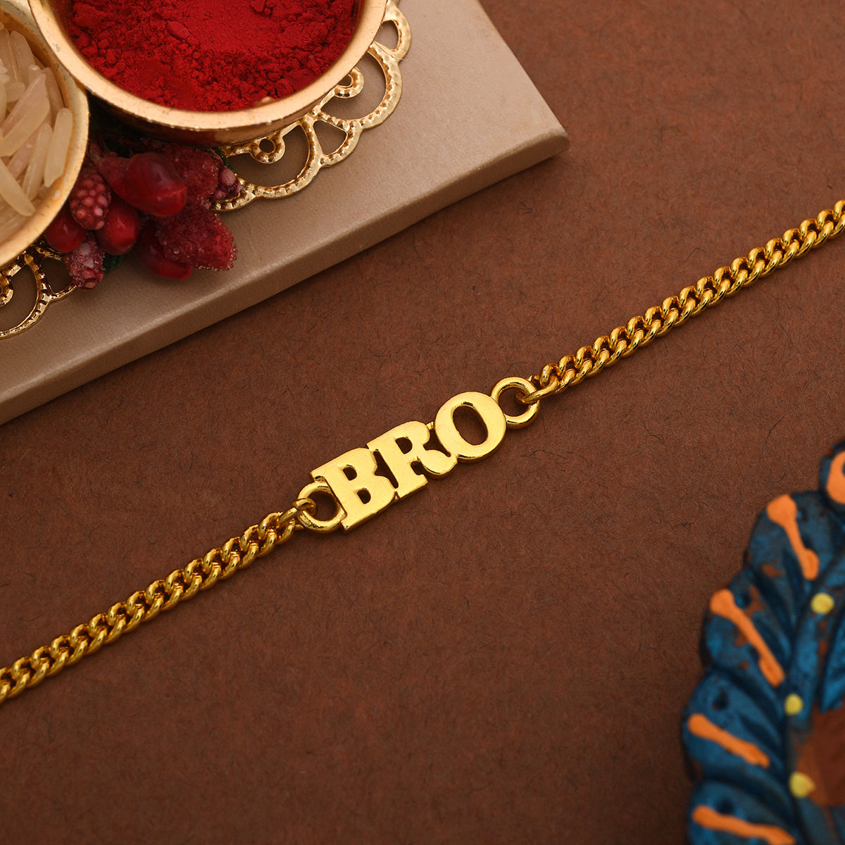 A stylish gold tone BRO rakhi designed as a sophisticated bracelet for men