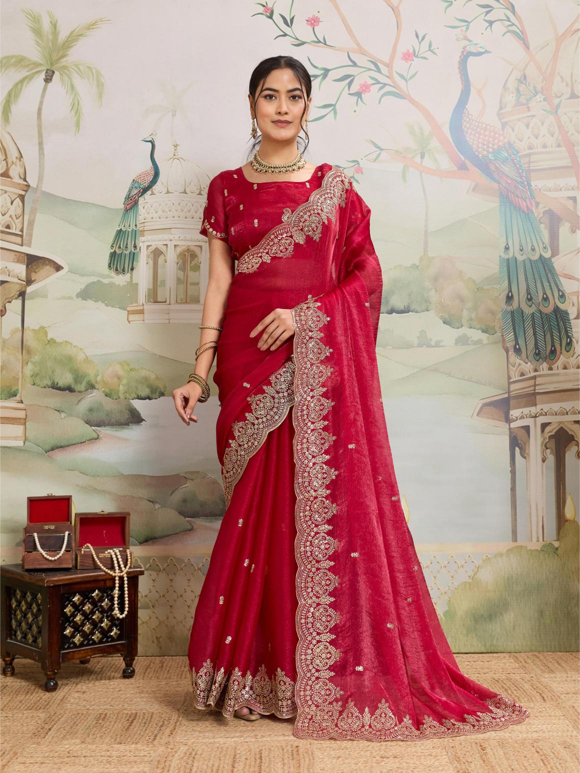 A beautiful red party wear Jimmy Choo Organza saree with intricate embroidery and matching unstitched blouse piece.