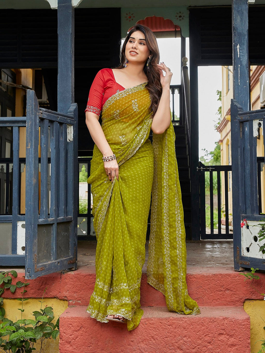 An elegant green embroidered Georgette party wear saree with an unstitched blouse piece.
