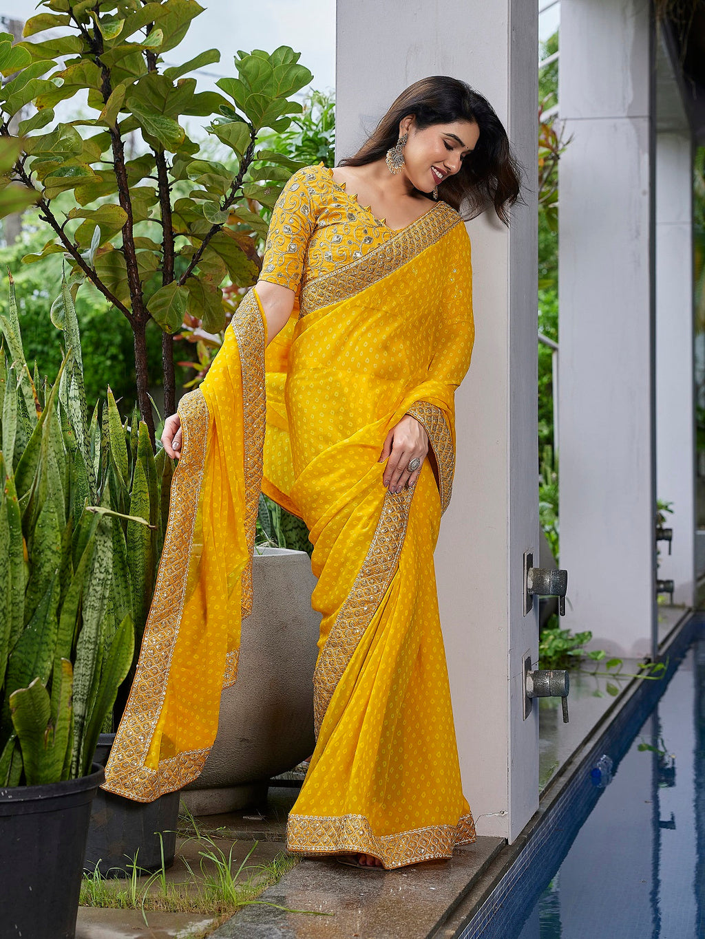 Bright yellow georgette saree featuring intricate embroidery and unstitched blouse
