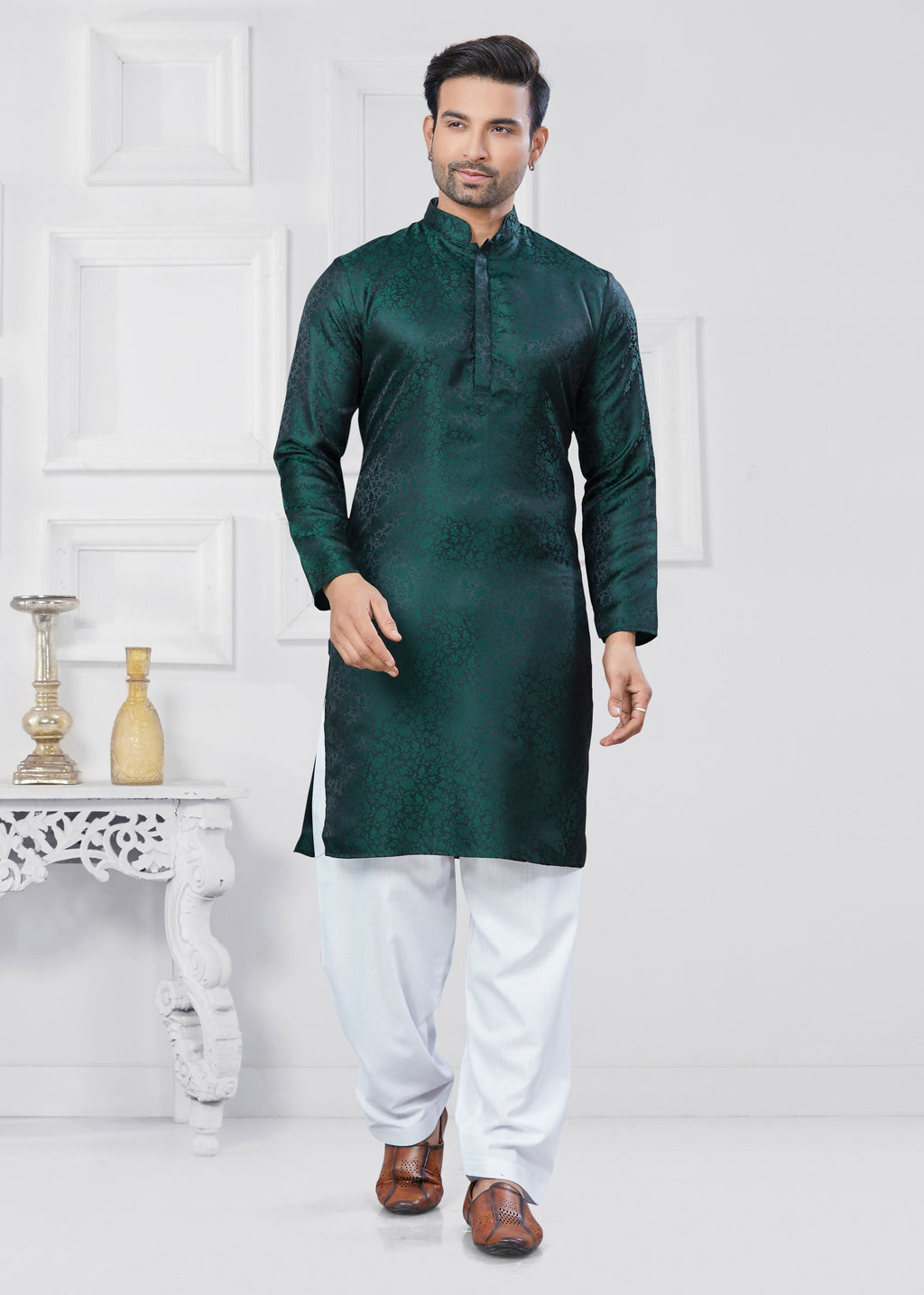 A young boy wearing a green jacquard silk printed kurta pyjama set with intricate patterns.