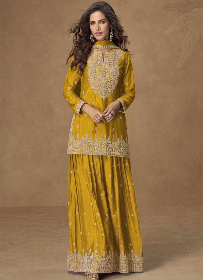 Woman wearing a yellow Chinon silk embroidered palazzo suit with gota patti detailing.