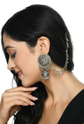 Close up of ornate oxidized silver Bahubali style jhumka earrings for girls