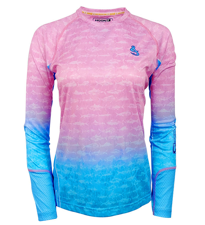 Woman wearing a pink and blue long sleeve UV fishing shirt with a fish pattern