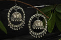 Traditional silver-plated Jhumka earrings featuring intricate Kundan detailing for ethnic wear.