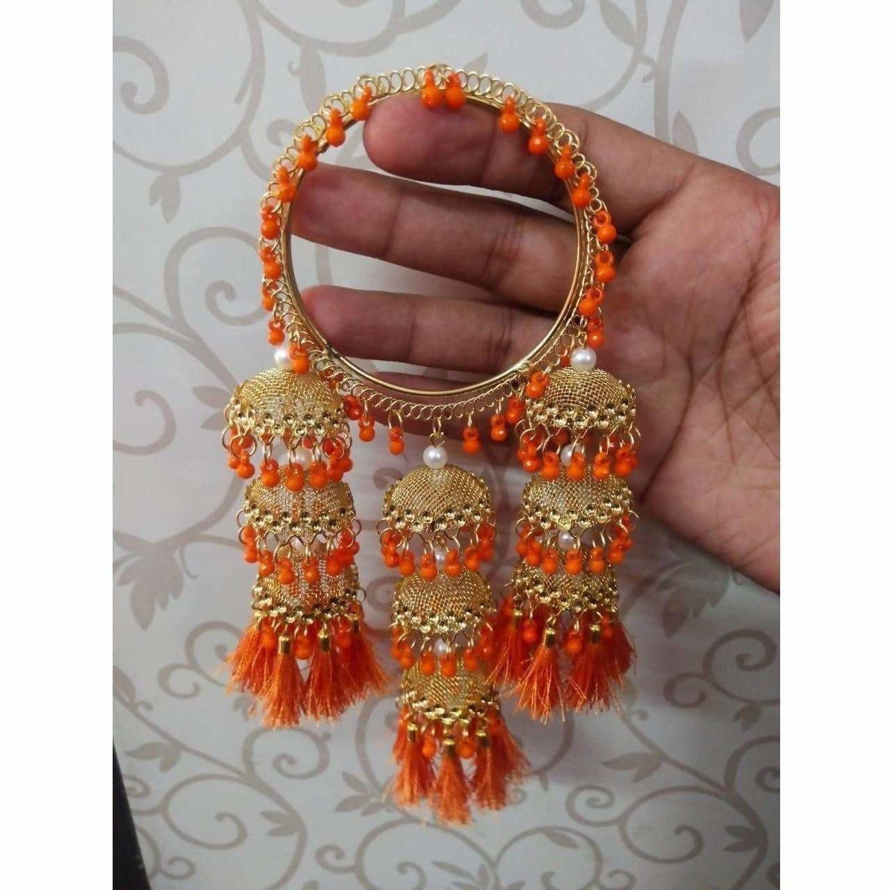Elegant gold-tone hanging jhumka bangles with orange pearls and silk threads for ethnic fashion