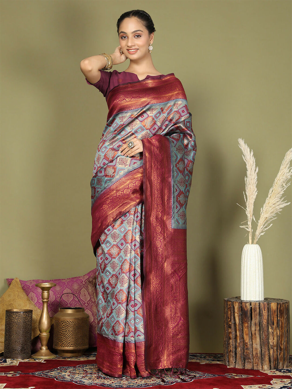 Teal Lichi Silk saree paired with a purple blouse.