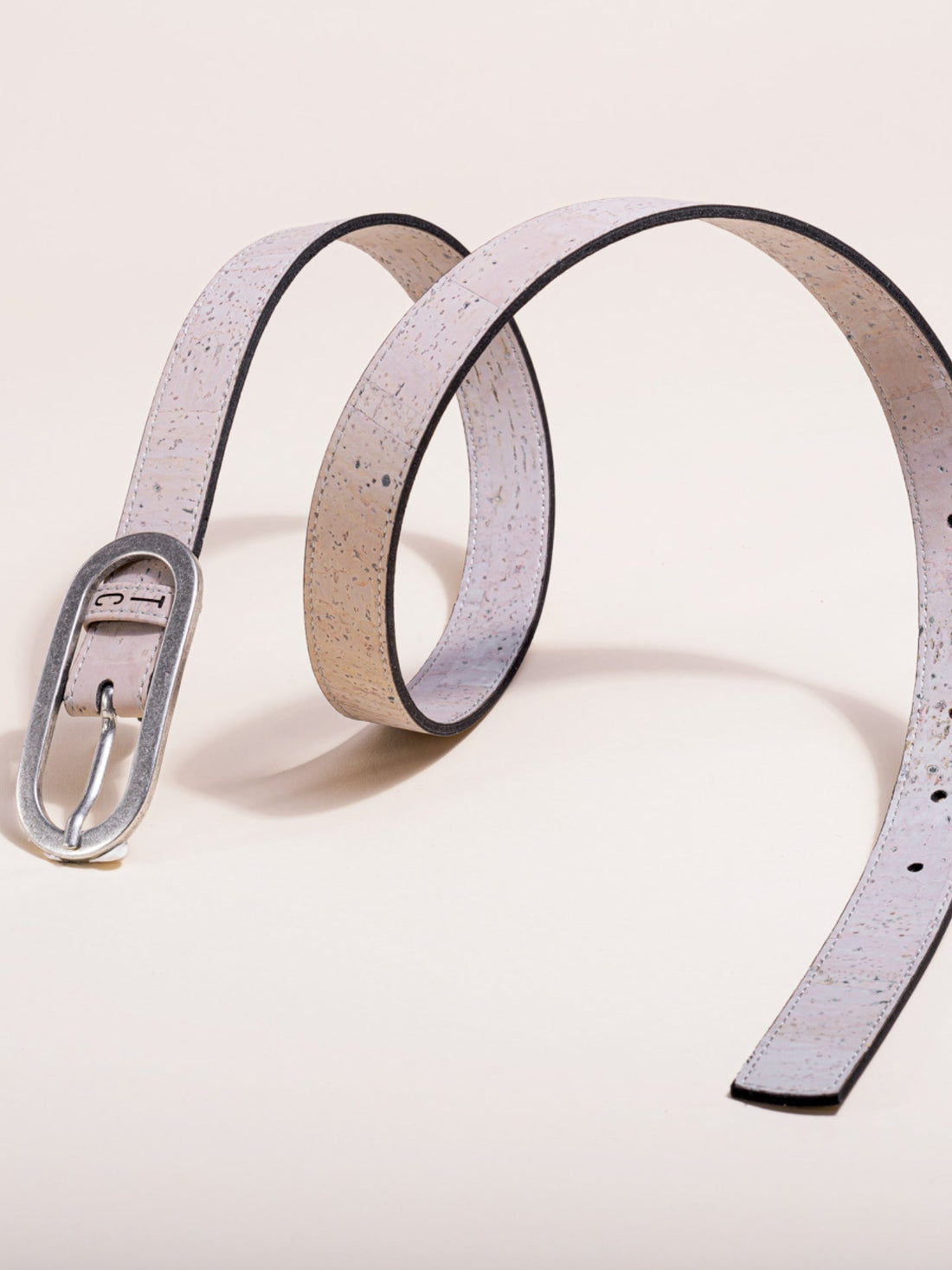 A close-up view of a gray vegan cork leather belt featuring a silver-toned metal buckle, displayed against a neutral background.
