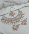 Sophisticated pink stone necklace set with matching earrings and traditional maang tikka, ideal for ethnic wear.