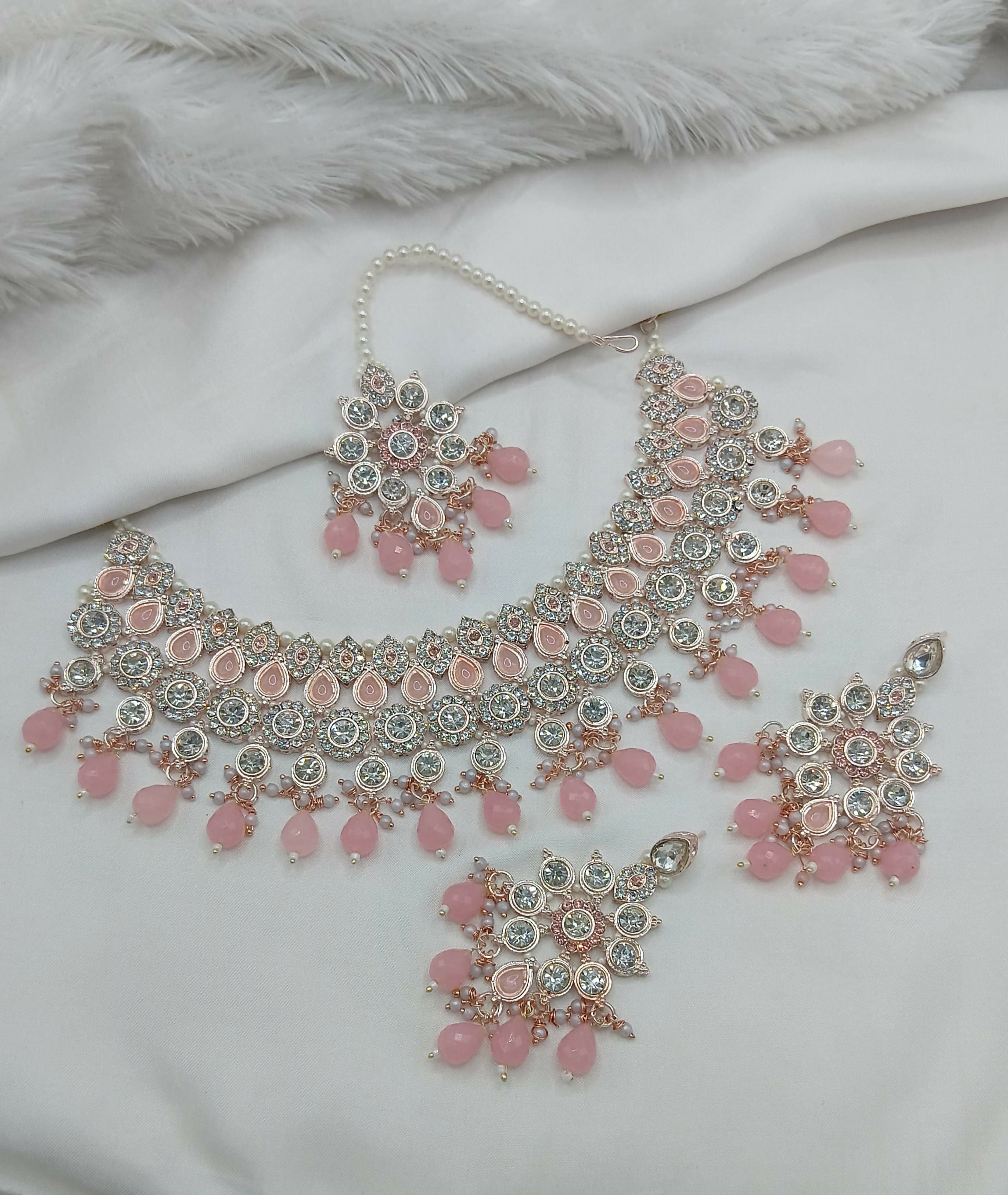 Sophisticated pink stone necklace set with matching earrings and traditional maang tikka, ideal for ethnic wear.